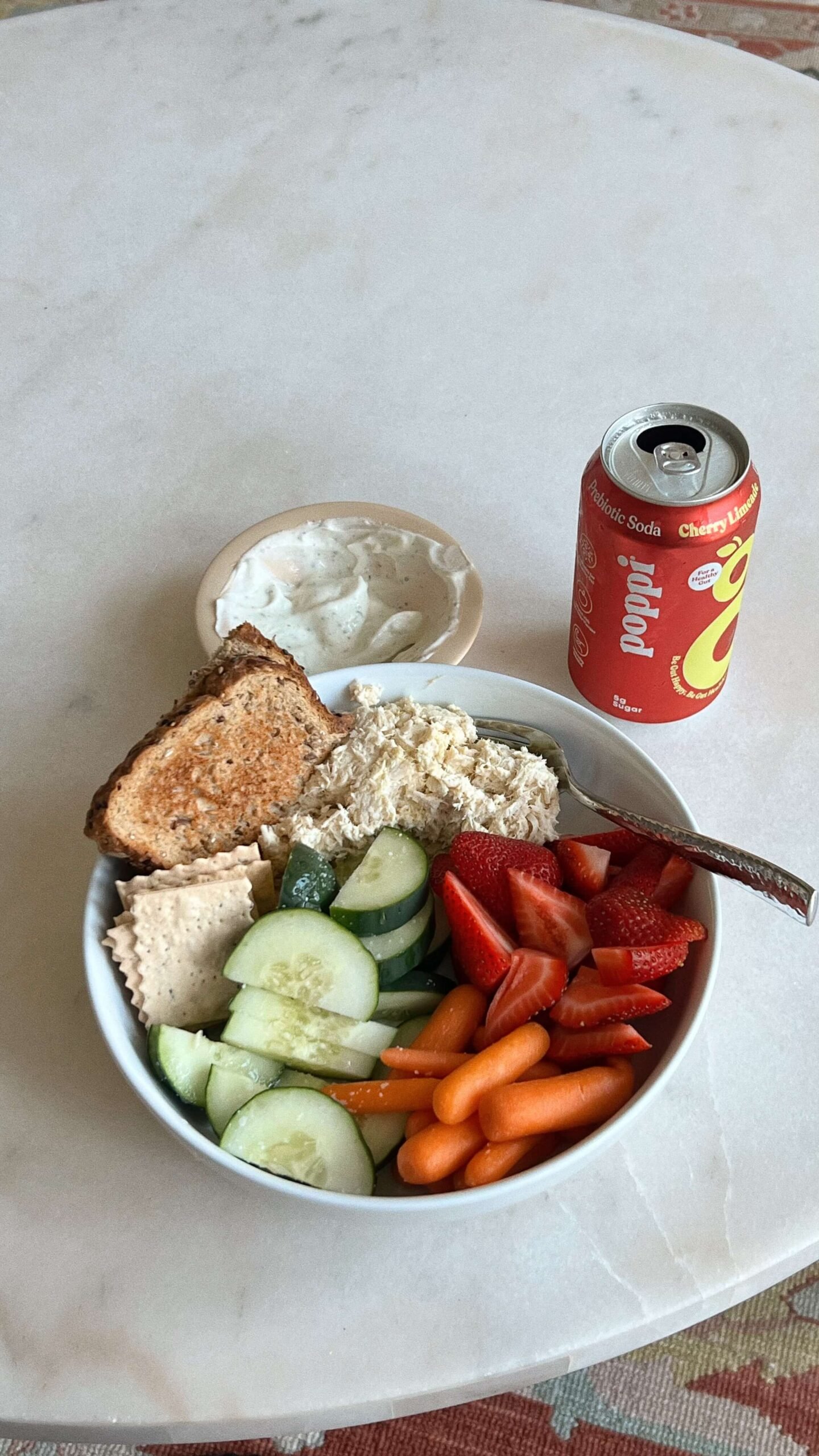 Eine Bowl und eine Getränkedose stehen auf einem Tisch.