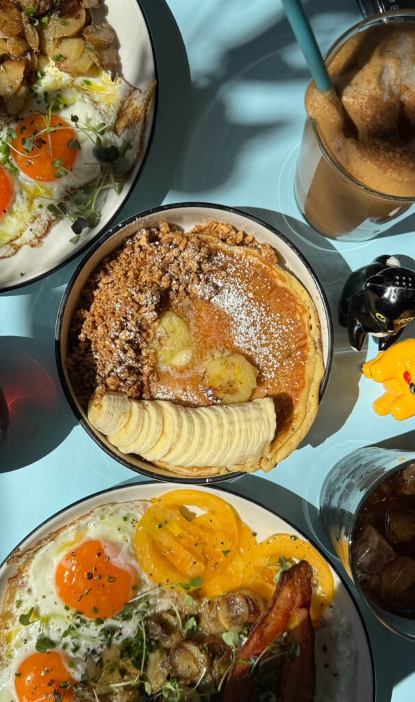 Zahlreiche Gerichte stehen auf einem Tisch mit blauer Tischdecke.