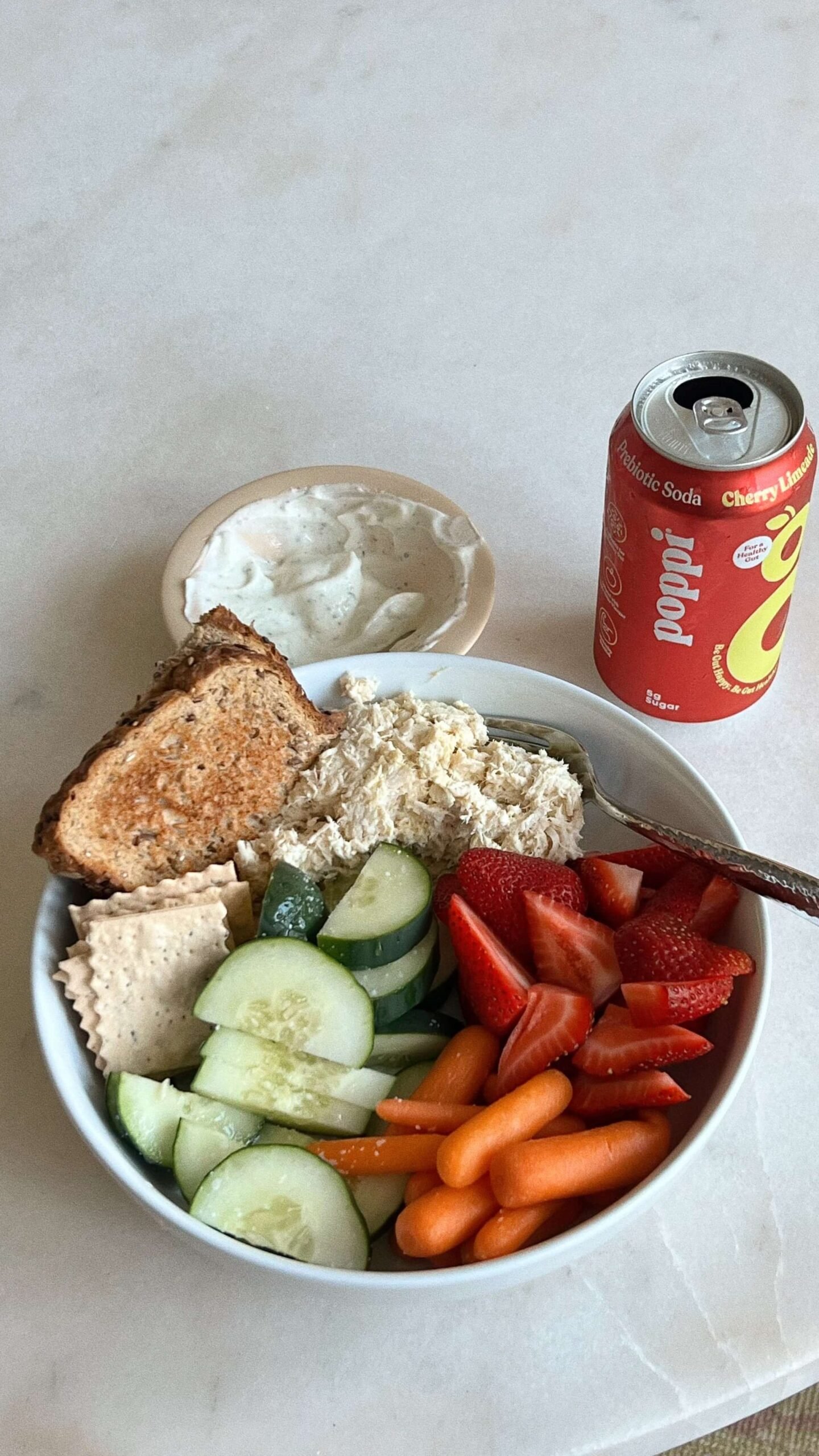 Eine Bowl und eine Getränkedose stehen auf einem Tisch.
